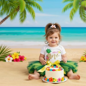 Può includere: Un body bianco a maniche corte con una grafica di ananas glitterata dorata e il testo sweet one, abbinato a una gonna tutù in tulle verde a più strati con un fiocco in nastro di raso giallo e una piccola torta rotonda decorata con fiori di glassa.
