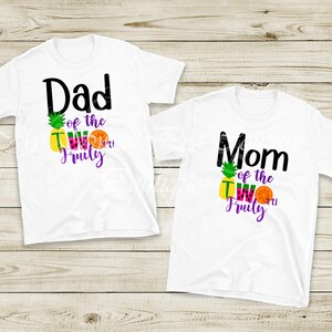Two white t-shirts with colorful text and graphics printed on them, one for a father and one for a mother.