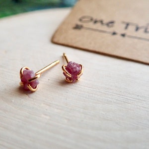 Puede incluir: Un par de pendientes de bot&oacute;n de oro con peque&ntilde;os acentos de piedras preciosas crudas de color rosa.