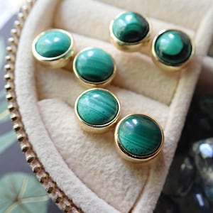May include: Six pairs of gold stud earrings with round green malachite stones.