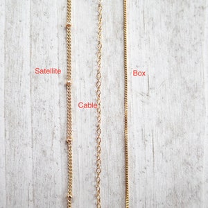 May include: Three gold chains, labeled "Satellite", "Cable", and "Box", are shown against a light wood background.