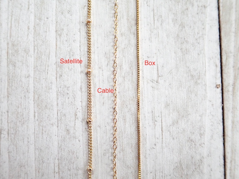 May include: Three gold chains, labeled "Satellite", "Cable", and "Box", are shown against a light wood background.