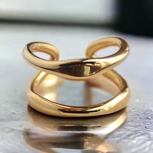 May include: A gold-toned double-ring ear cuff. The ear cuff is made of two smooth, curved bands that are connected together.