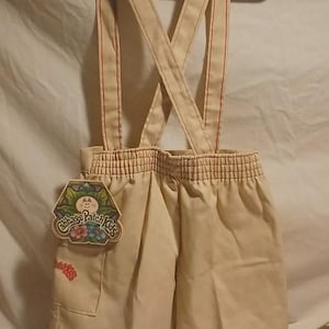 May include: A white ceramic mug with a black handle and the text "But First, Coffee" in a bold, black font. The mug is filled with a dark liquid, likely coffee, and sits on a light-colored surface.