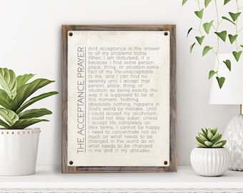 May include: A rustic wooden sign with a white background and black text. The sign features a quote about acceptance and serenity. The text reads "The Acceptance Prayer" and "And acceptance is the answer to all my problems today. When I am disturbed, it is because I find some person, place, thing, or situation-some fact of my life-unacceptable to me, and I can find no serenity until I accept that person, place, thing, or situation as being exactly the way it is supposed to be at this moment. Nothing, absolutely nothing, happens in God's world by mistake. Until I could accept my alcoholism, I could not stay sober, unless I accept life completely on life's terms, I cannot be happy. I need to concentrate not so much on what needs to be changed in the world as on what needs to be changed in me and in my attitudes."