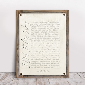 May include: A vintage-style print with a wood frame features the lyrics to the song "I Did It My Way" by Frank Sinatra. The lyrics are printed in black ink on a cream-colored background.