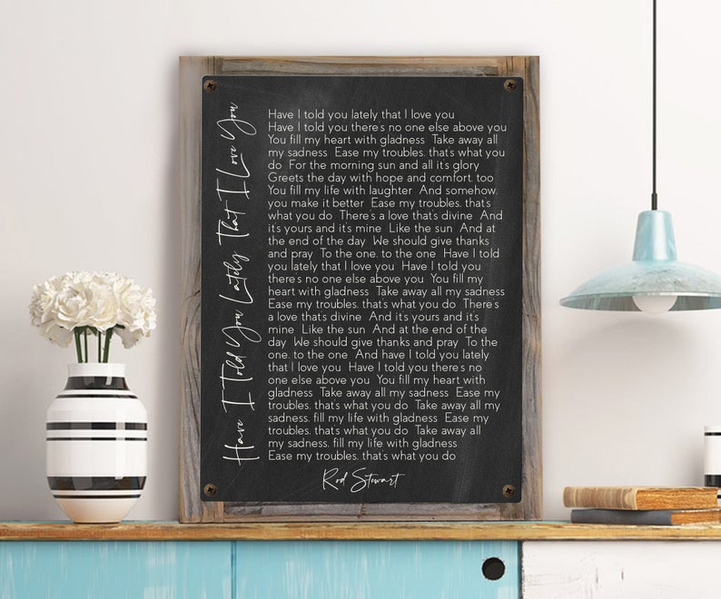 May include: Black and white print of a song lyric on a wooden background. The lyrics are for the song "Have I Told You Lately That I Love You" by Rod Stewart.