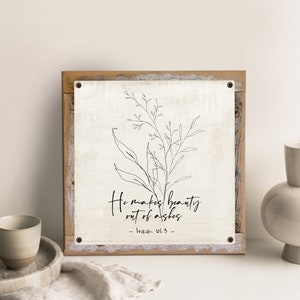May include: A white canvas print with a black line drawing of a flower and the text "He makes beauty out of ashes - Isaiah 61:3 - "