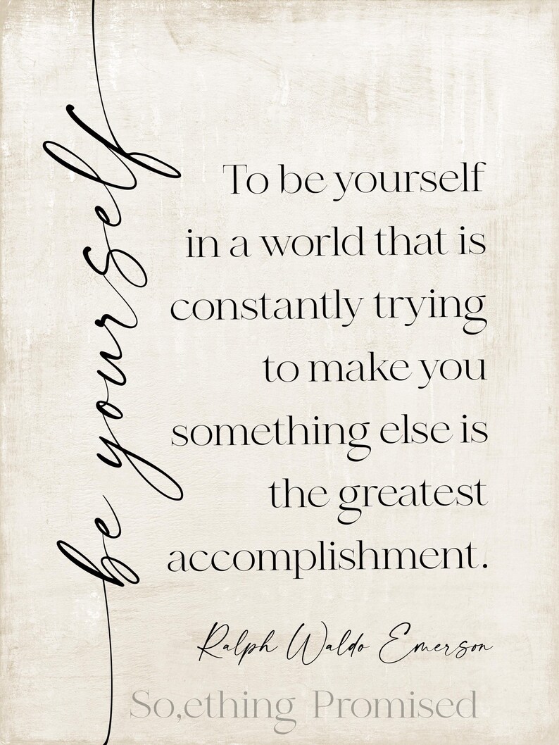 May include: A rectangular print with a beige background and black text. The text reads "To be yourself in a world that is constantly trying to make you something else is the greatest accomplishment." The author is Ralph Waldo Emerson.