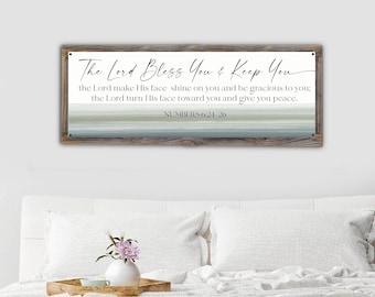 May include: A rectangular wooden framed wall art piece with the text "The Lord Bless You & Keep You" and a scripture from Numbers 6:24-26. The background features horizontal stripes in shades of blue, gray, and white.