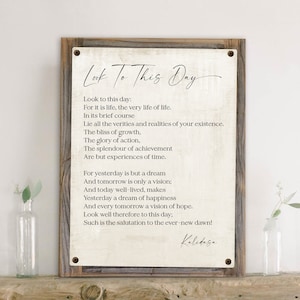 May include: A framed print with a white background and black text. The text is a poem titled "Look To This Day" by Kalidasa. The poem is about appreciating the present moment and living life to the fullest.