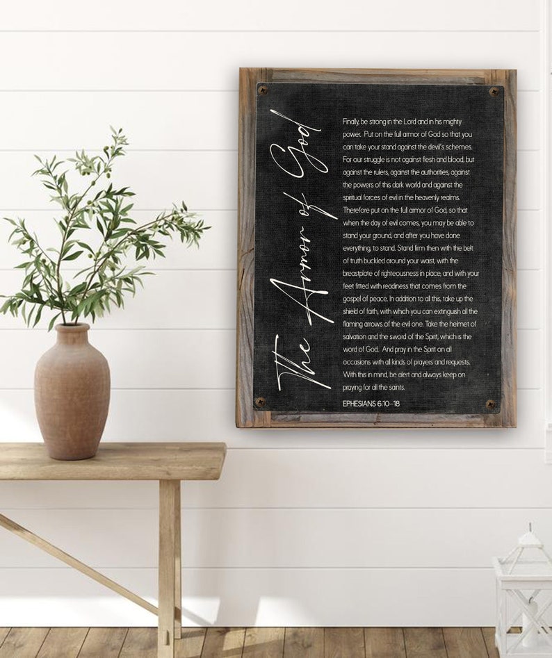 K&ouml;nnte beinhalten: Ein schwarz-wei&szlig;es Schild mit einem Holzrahmen. Das Schild zeigt ein Zitat aus Epheser 6,10-18 &uuml;ber die R&uuml;stung Gottes. Der Text ist in einer stilisierten Schriftart geschrieben und enth&auml;lt die Worte "Die R&uuml;stung Gottes".