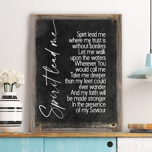 K&ouml;nnte beinhalten: Ein schwarz-wei&szlig;es Schild mit einem rustikalen Holzrahmen. Das Schild zeigt ein christliches Kirchenlied mit dem Text "Spirit lead me where my trust is without borders. Let me walk upon the waters. Wherever You would call me. Take me deeper than my feet could ever wander. And my faith will be made stronger in the presence of my Saviour."