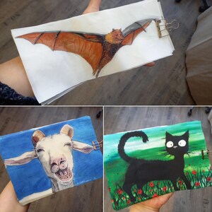 Könnte beinhalten: Drei verschiedene Stoffbahnen mit Illustrationen. Die erste Bahn zeigt eine braune Fledermaus vor weißem Hintergrund. Die zweite Bahn zeigt eine weiße Ziege vor blauem Hintergrund. Die dritte Bahn zeigt eine schwarze Katze vor grünem Hintergrund mit weißen Blumen.