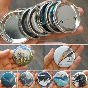 Könnte beinhalten: Ein Set mit zehn 5 cm großen Anstecknadeln mit verschiedenen Designs. Die Designs umfassen ein Schaf, ein Faultier, einen Mond, eine Katze, eine Welle und ein Monster.