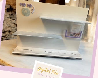 May include: Digital file for a shelf display with two shelves and a small compartment. The display is white with a light purple accent. The text "Tap Me" is on the top of the display.