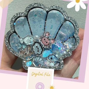 May include: A silver glitter resin seashell charm with a blue and white glitter interior. The charm features various small sea-themed charms, including a narwhal, a crab, a seashell, and a whale. The charm is labeled "Digital File".