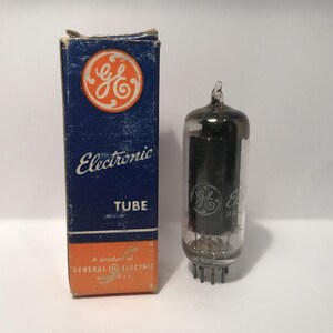 May include: Vintage General Electric electronic tube with its original box. The box is blue and orange with the GE logo and the words "Electronic TUBE". The tube is glass with a metal base.