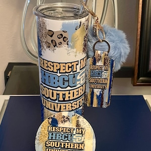 May include: A stainless steel tumbler with a blue, gold, and white design that says "Respect My HBCU Southern University". The tumbler comes with a matching coaster and a keychain with a blue pom-pom.