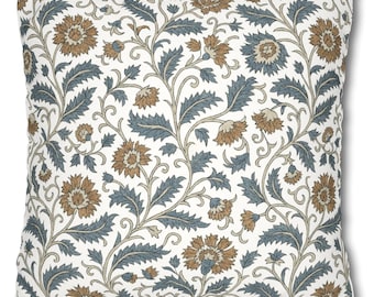 May include: A white cushion with a floral pattern in shades of brown and blue. The pattern features intricate floral designs with leaves and flowers.