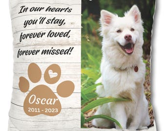 May include: A white memorial pillow with a brown paw print and the text "In our hearts you'll stay, forever loved, forever missed!"  The paw print has a small heart in the center and the text "Oscar 2011 - 2023" below it. A photo of a white dog sitting in grass is on the right side of the pillow.