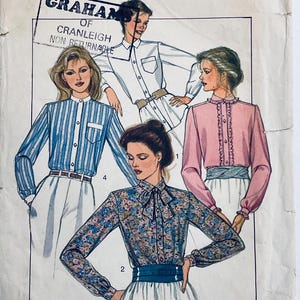Könnte beinhalten: Vintage Schnittmuster mit Illustrationen von Damenblusen. Die Blusen umfassen ein gestreiftes Knopfhemd, ein weißes Hemd mit Kragen, ein rosa Oberteil mit Rüschen und eine Bluse mit Blumenmuster und Schleife. Das Muster ist mit "GRAHAM OF CRANLEIGH NON RETURNABLE" gekennzeichnet.