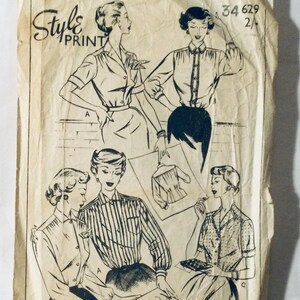 May include: Vintage sewing pattern for a blouse with a collar and button fastening. The pattern is printed on white paper with black ink and shows four different styles of blouses. The pattern number is 34 629 2/.