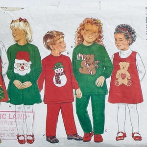 Pode incluir: Um padrão de costura para roupas infantis com cinco designs diferentes. Os designs incluem um colete vermelho com uma saia verde, um vestido verde com uma aplicação de Papai Noel, um suéter vermelho com uma aplicação de boneco de neve, um suéter verde com uma aplicação de urso e um vestido vermelho com uma aplicação de urso. O padrão é da Butterick e é para os tamanhos 2-3-4-5.