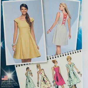 May include: A sewing pattern booklet featuring five different dress designs. The cover shows two women wearing dresses, one with a yellow dress and the other with a white dress with red criss-cross straps in the back. The booklet includes instructions for making the dresses.