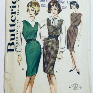 May include: Vintage sewing pattern for a dress with a Peter Pan collar. The pattern is for a sleeveless dress with a fitted bodice and a skirt that falls to the knee. The pattern is illustrated with three women wearing different versions of the dress.