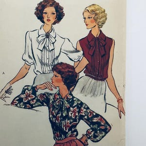 May include: A vintage sewing pattern illustration featuring three figures wearing blouses with pussy-bow necklines. One figure wears a white short-sleeved blouse, another a sleeveless maroon blouse, and the third a long-sleeved floral print blouse.