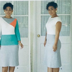 May include: Two women wearing different versions of a dress with a white top, teal middle section, and a gray bottom. The dress on the left has a red and white geometric pattern on the top. Both women are wearing gold earrings.