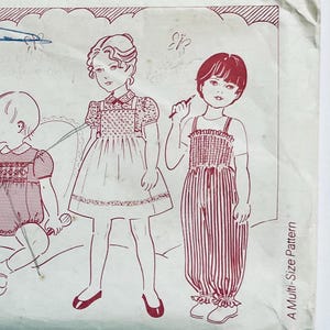 Puede incluir: Un patrón de costura para ropa de niños. El patrón incluye tres diseños diferentes: un vestido con babero, un jersey con babero y un mono. El patrón está impreso en papel blanco con tinta roja. El texto "A Multi-Size Pattern" está impreso en el lado derecho de la página.