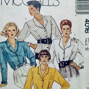 May include: A sewing pattern for a blouse with three different styles. The pattern is for size 12 and is from McCall's. The pattern shows three women wearing different versions of the blouse. One woman is wearing a white blouse with black polka dots, another is wearing a light blue blouse, and the third is wearing a yellow blouse.