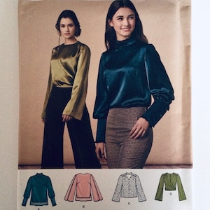 Op de afbeelding: Twee vrouwen tonen blouses en broeken. Eén vrouw draagt een olijfgroene blouse met wijde mouwen en een zwarte broek. De andere draagt een blauwgroene blouse met een hoge hals en een bruin geruite broek. Hieronder illustraties van verschillende bloesemstijlen.