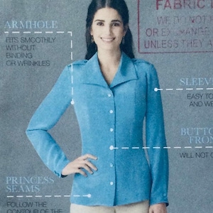 May include: A light blue button-up shirt with a collar and long sleeves. The shirt has a princess seam detail and the text "ARMHOLE" and "SLEEVES" is visible on the image. The text "FITS SMOOTHLY WITHOUT BINDING OR WRINKLES" is visible on the image. The text "EASY TO FIT AND WEAR" is visible on the image. The text "BUTTON FRONT WILL NOT GAP" is visible on the image.