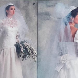 May include: Two white wedding dresses with veils. The left dress features a high lace neckline and long lace sleeves. The right dress has puffed sleeves, a low back with a large bow, and a headpiece with a veil. Both are labelled with letters D and A.