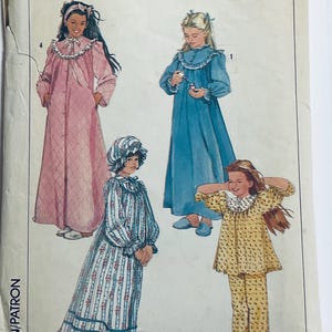 May include: A vintage sewing pattern for girls' nightgowns. The pattern includes four different styles, each with a different neckline and sleeve length. The pattern is illustrated with drawings of girls wearing the nightgowns.