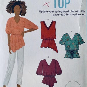 May include: A sewing pattern for a gathered 3-in-1 peplum top. The pattern includes three different styles: a sleeveless top, a top with short sleeves, and a top with 3/4 sleeves. The pattern is illustrated with a woman wearing the top in a peach color with white polka dots.