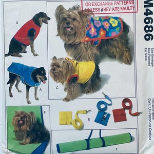 May include: A pattern for dog clothing, featuring illustrations of dogs wearing coats in red, blue, and yellow. Accessories include leashes, small bags, and a green bed roll. The text "OR EXCHANGE PATTERNS UNLESS THEY ARE FAULTY" is visible.
