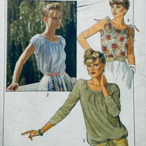 Pode incluir: Um padrão de costura com três estilos diferentes de blusas. A primeira blusa é de manga comprida, de cor verde claro com um decote franzido. A segunda blusa é de manga curta, de cor azul claro com um decote franzido. A terceira blusa é sem mangas, de estampa floral com um decote franzido e alças de laço.