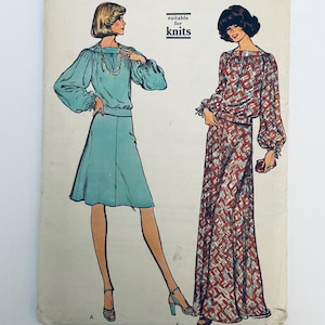 May include: A sewing pattern envelope featuring illustrations of two outfits with long, gathered sleeves and gathered necklines. One outfit is a solid light blue top and skirt, while the other is a patterned top and floor-length skirt. Text reads: SUITABLE for knits.