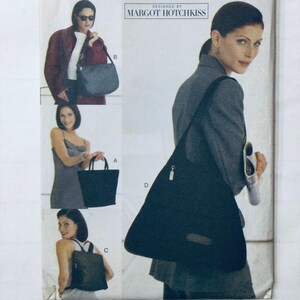 May include: A sewing pattern featuring four different styles of bags. The bags are all black and made of a fabric with a slight sheen. The pattern is designed by Margot Hotchkiss.