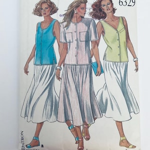 Könnte beinhalten: Ein Schnittmusterumschlag mit der Nummer 6329, der Illustrationen von drei Outfits zeigt. Jedes Outfit besteht aus einem langen, fließenden weißen Rock, kombiniert mit einem ärmellosen blauen Oberteil, einem gestreiften Kurzarmhemd oder einem hellgrünen Top.