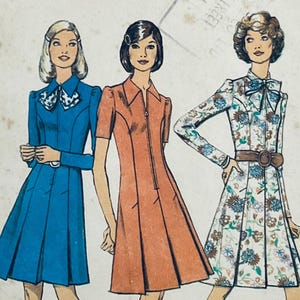May include: Three vintage dress patterns featuring a blue, orange, and floral print dress. The patterns are for a collared dress with a zip closure.