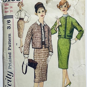 May include: Vintage sewing pattern for a skirt and jacket set. The pattern is printed on paper and features illustrations of two women wearing the outfit. The pattern is for sizes 14 and 34.