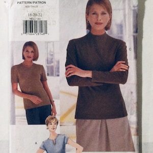 May include: A sewing pattern for a long-sleeved shirt and a short-sleeved shirt. The pattern is for sizes 18-20-22. The pattern is shown on two models. The model on the left is wearing a brown short-sleeved shirt and blue jeans. The model on the right is wearing a brown long-sleeved shirt and a beige skirt.