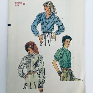 Könnte beinhalten: Ein Schnittmusterumschlag in Größe 16 mit Illustrationen von drei Hemden. Dargestellt sind ein langärmeliges blaues Hemd, ein langärmeliges gestreiftes Hemd mit Schleife am Kragen sowie ein kurzärmeliges grünes Hemd mit Knopfleiste.