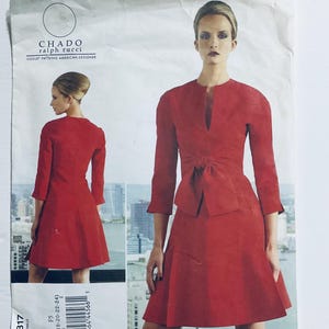 Pode incluir: Um padrão de vestido vermelho de Chado Ralph Rucci. O padrão apresenta um vestido com decote em V, mangas três quartos e um detalhe de laço na cintura. O padrão também inclui uma vista do vestido de trás. O padrão é para Vogue Patterning American Designer.