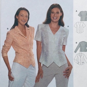 May include: Two women modeling different styles of blouses. The woman on the left is wearing a peach-colored blazer with a pointed collar and long sleeves. The woman on the right is wearing a light blue blouse with a V-neck and short sleeves. Both blouses have a button-up front.
